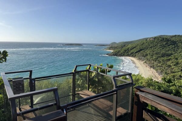 Hill Hiker Outdoor Elevator Trolley Car at top landing overlooking a sand beach on a tropical island shoreline