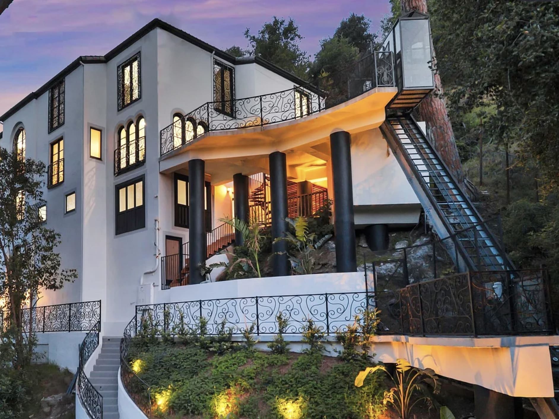 A Hill Hiker residential inclined elevator installed on a steep wooded hillside next to a multi-story home in Beverly Hills, California.