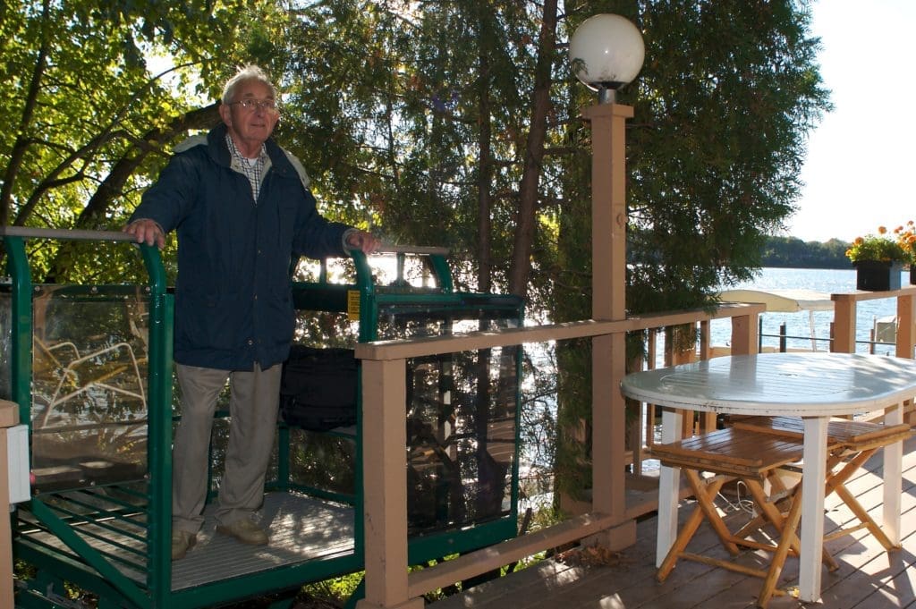 Personal residential funicular system helping an elderly man eliminate the physical challenge of a steep incline